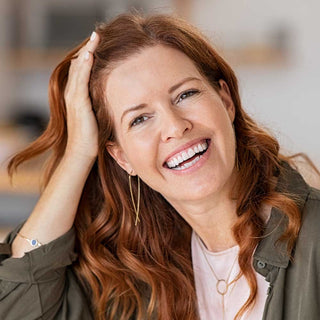Woman with red hair smiling indoors