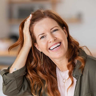 Woman with red hair smiling indoors