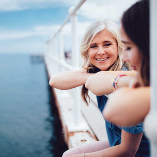 Two women on a boat with a scenic background